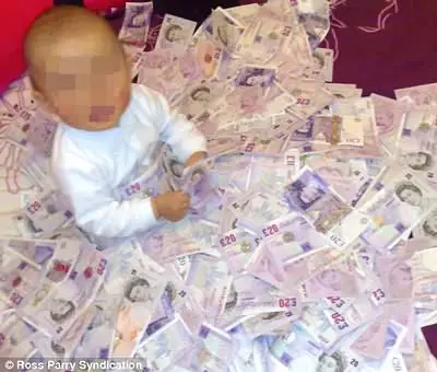 Scammer's baby on bed of cash